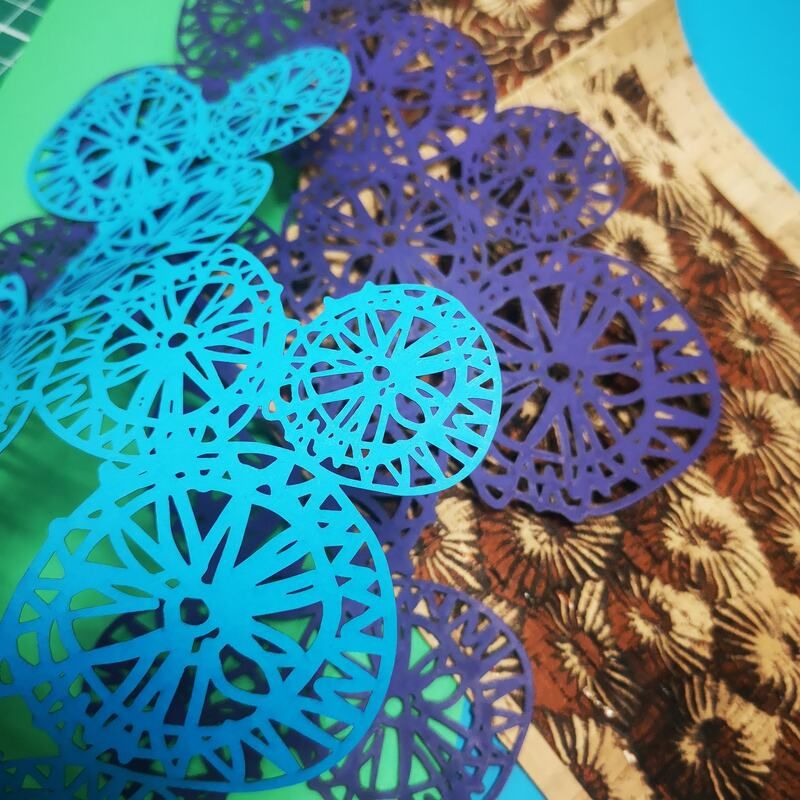 laser cut circular blue/purple paper with patterns inside