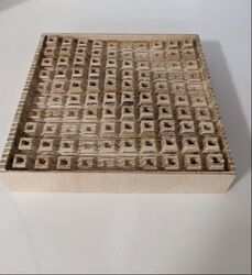 CNC cut block of wood with square detail